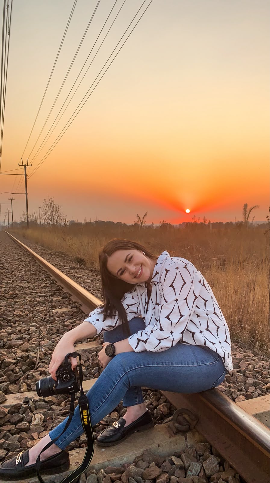 Veronique Van Der Walt, photographer, at sunset with her camera on the railway tracks near Middelburg